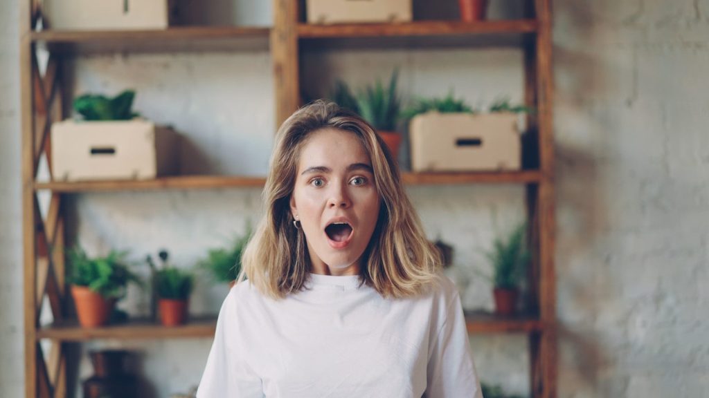 Young woman with surprised expression looking forward.