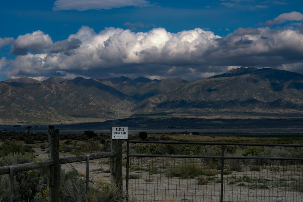 a fenced in area with mountains in the background