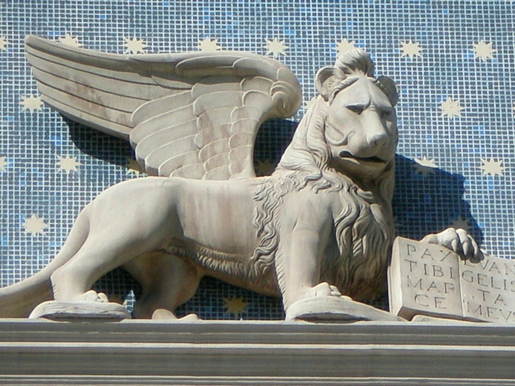 a statue of a lion with wings on top of a building