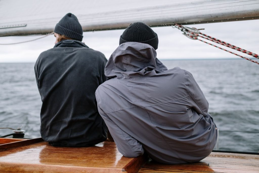 Two people on a sailboat enjoying a tranquil ocean view, perfect travel moment.