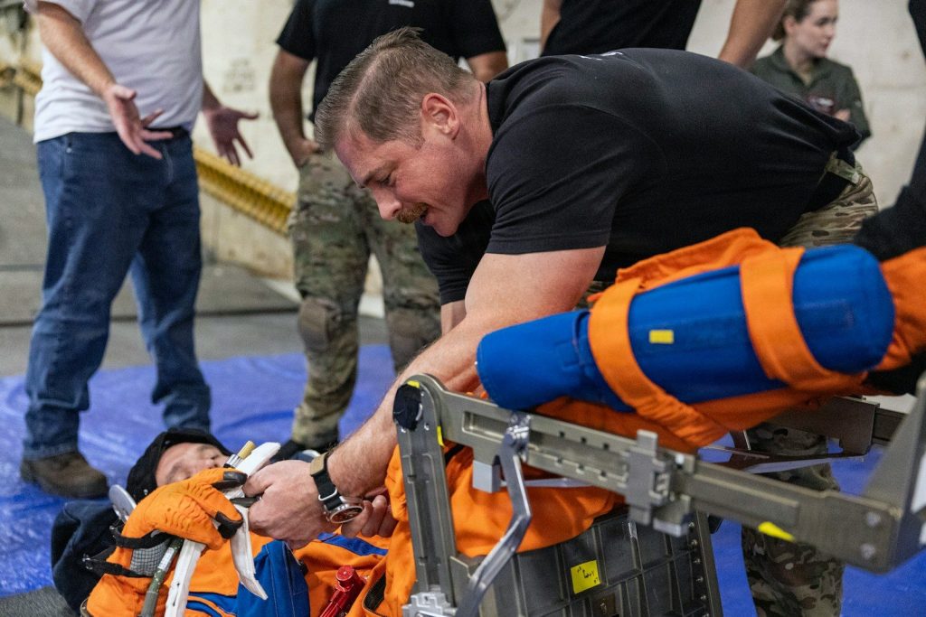 Medical professionals stabilize a patient on a stretcher.