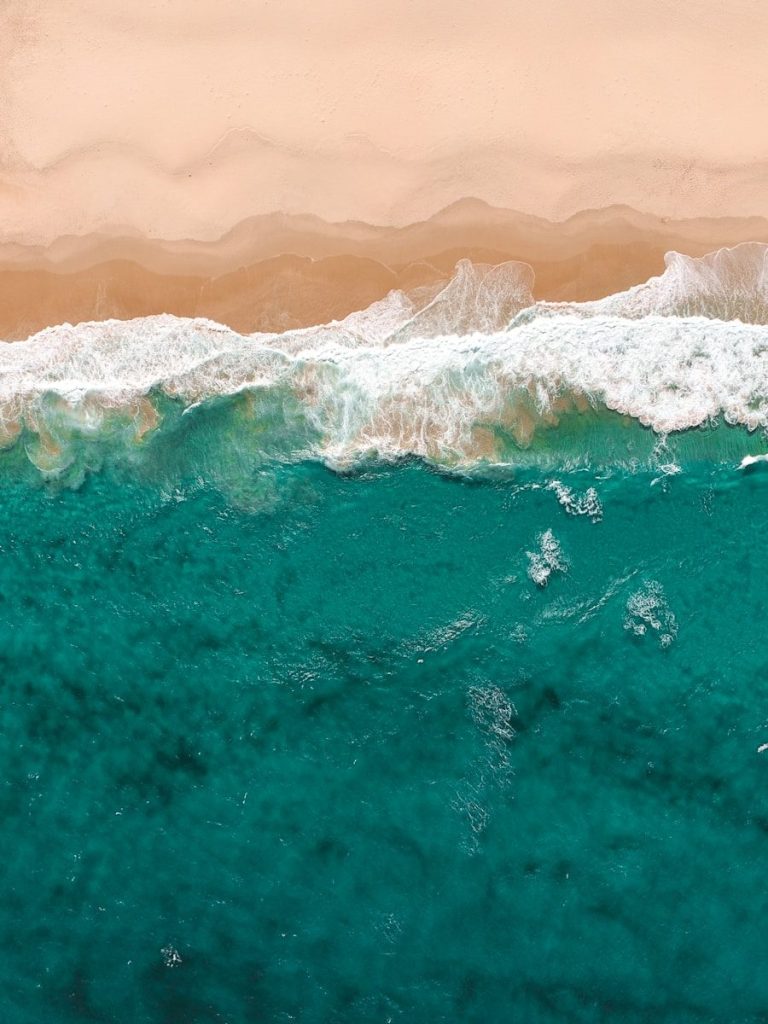 aerial view of waves meeting sand