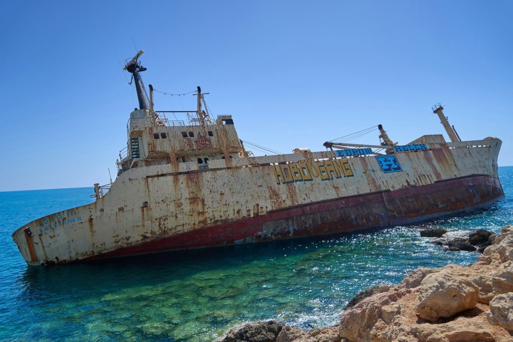 A rusted ship sitting in the middle of the ocean