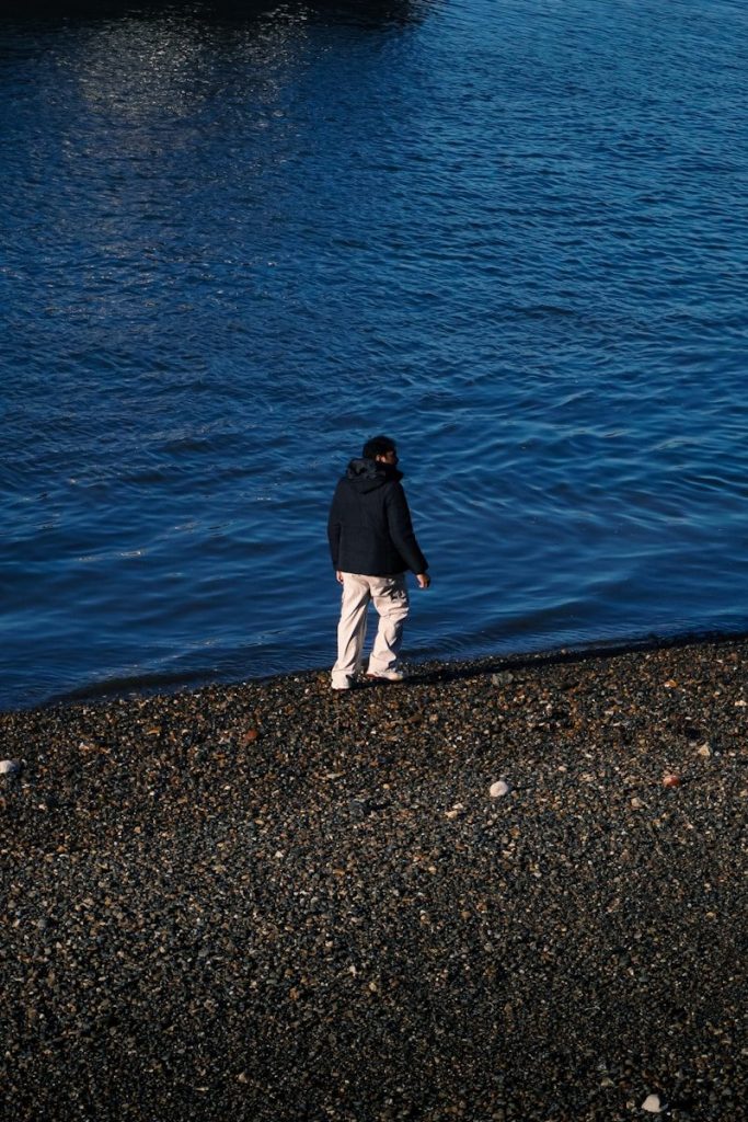 A person stands near the water's edge.