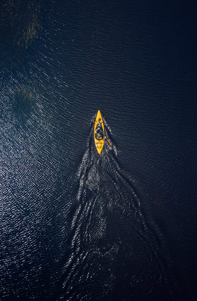 yellow and black surfboard on body of water