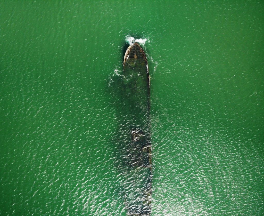 a large boat floating on top of a green body of water