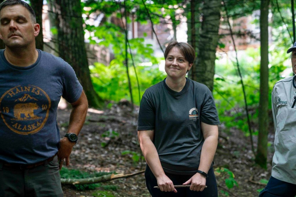 Three people standing in a forest