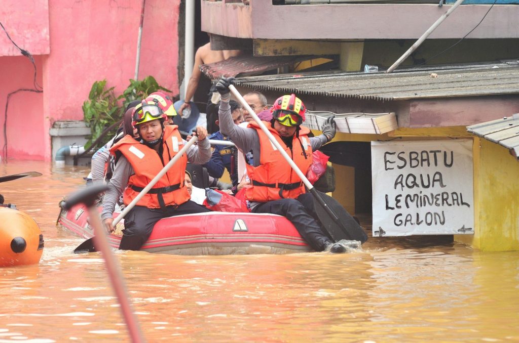 Rescue workers navigate floodwaters in a boat.