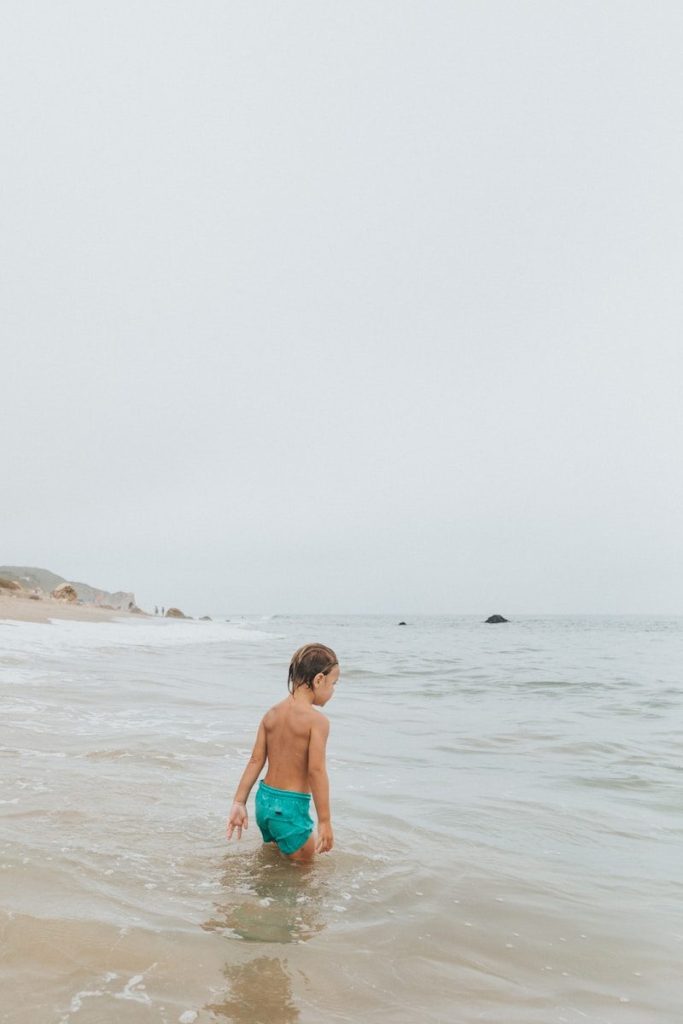 woman in blue bikini standing on beach during daytime