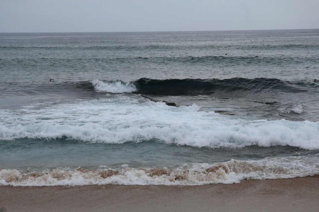 A body of water with waves coming in to shore