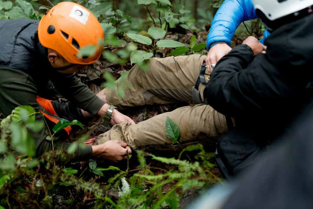 A man in an orange helmet is on the ground