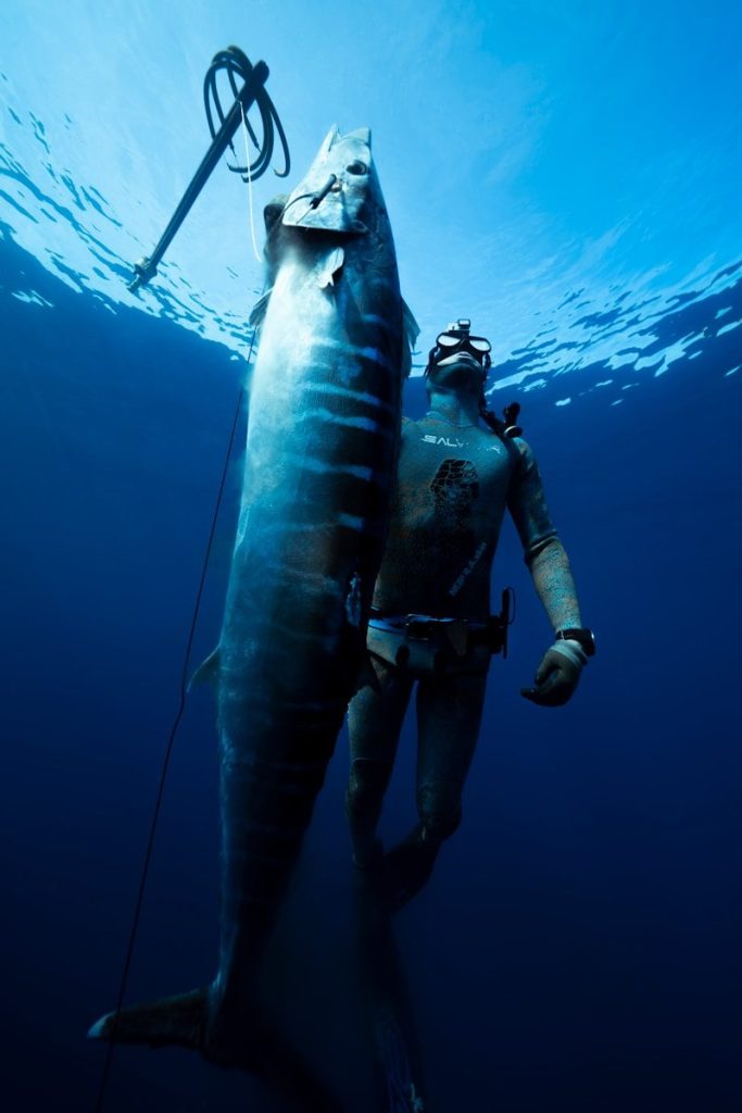 a man holding a large fish in the water