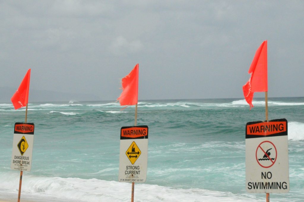 red and white flag on beach during daytime