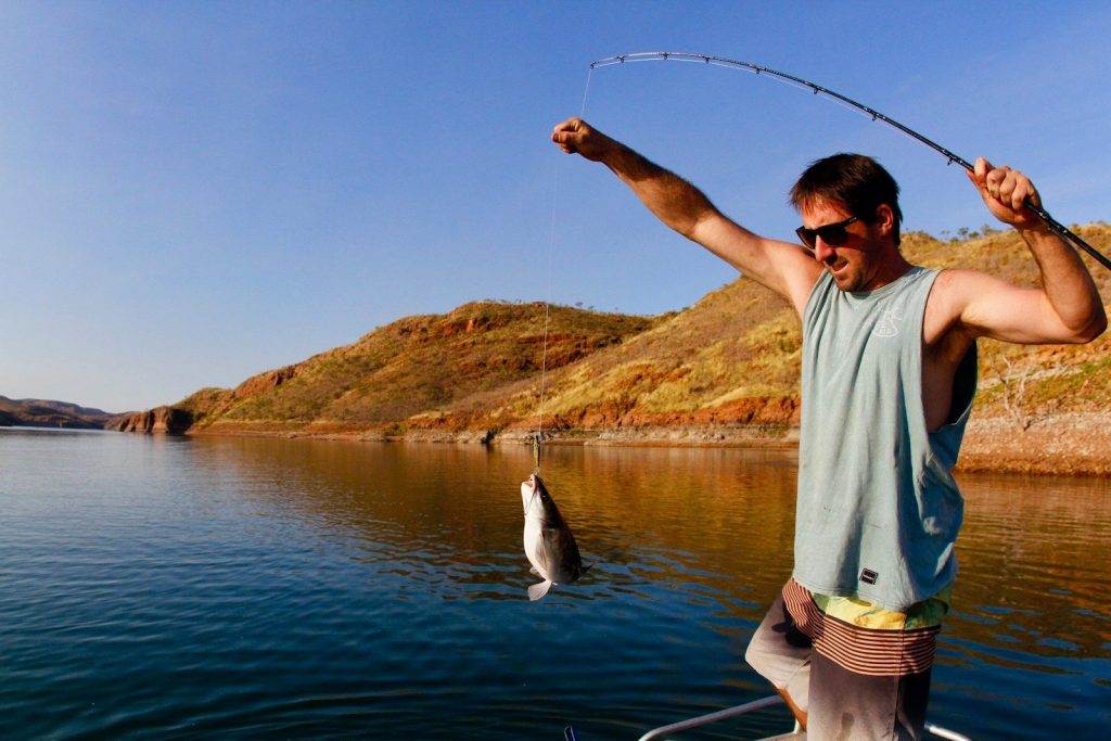 man catching fish with his fishing rod
