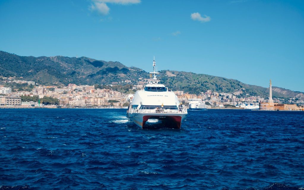 A white ferry boat sailing on the blue ocean