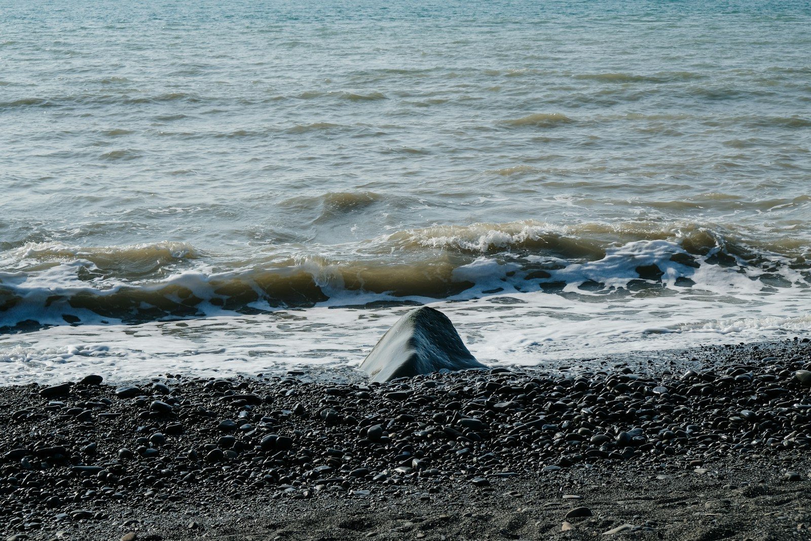 a surfboard laying on the beach next to the ocean