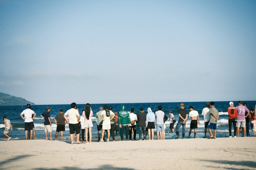 People gathered on a sandy beach by the ocean.