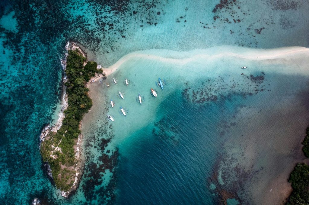 Aerial view of an island with boats in the water.